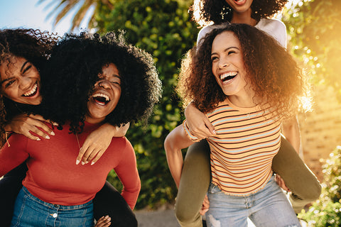 friends with beautiful hair laughing in the sun 